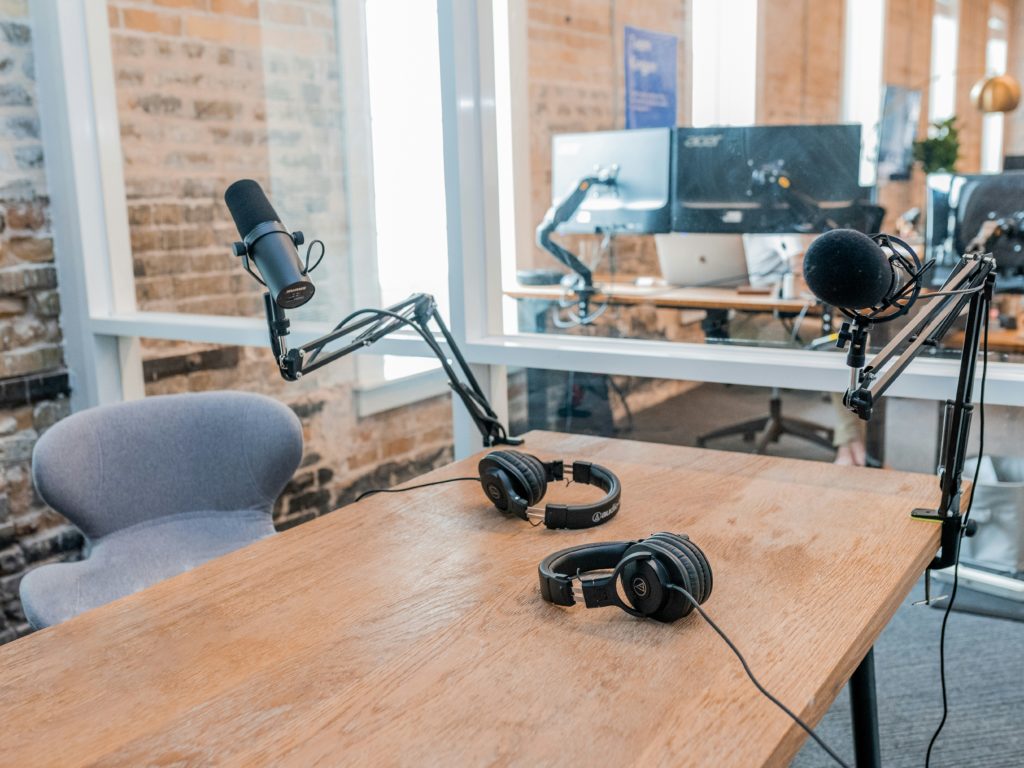 two microphones on a desk with a computer in the background